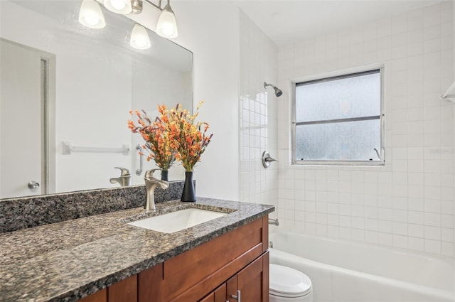 full bathroom featuring vanity, tiled shower / bath combo, and toilet