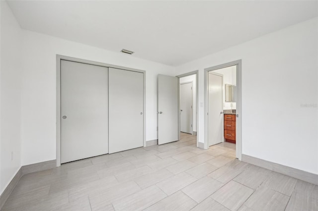 unfurnished bedroom featuring ensuite bathroom and a closet