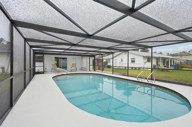 view of pool with a patio, glass enclosure, and a lawn