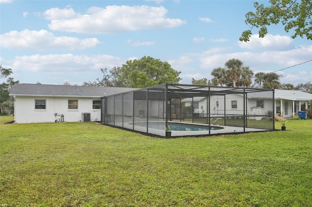 rear view of house featuring a lanai, central AC, and a lawn