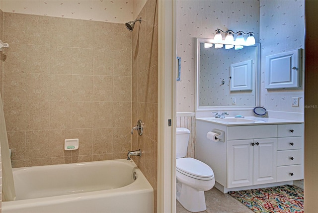 full bathroom with tile patterned flooring, tiled shower / bath, vanity, and toilet