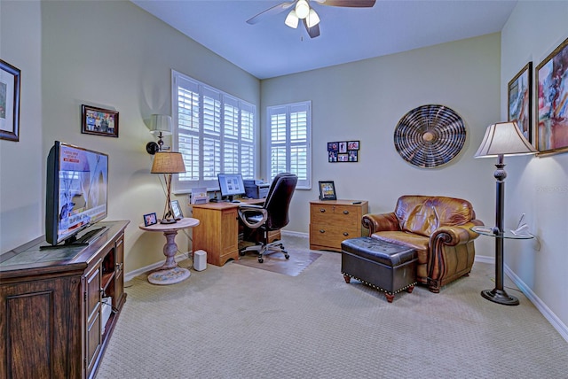 carpeted home office featuring ceiling fan