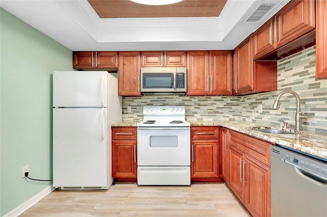 kitchen featuring stainless steel appliances, light stone countertops, sink, and decorative backsplash