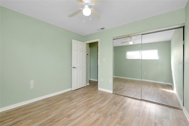 unfurnished bedroom with light hardwood / wood-style floors, ceiling fan, and a closet