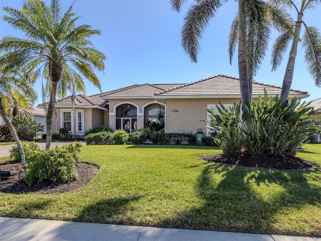 mediterranean / spanish home with a front yard