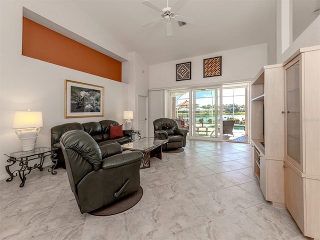 living room with a towering ceiling and ceiling fan