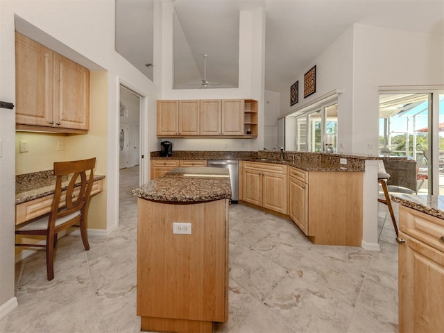 kitchen with sink, a center island, light brown cabinets, dishwasher, and dark stone counters