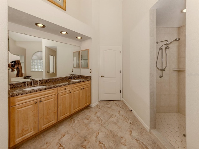 bathroom with vanity and a tile shower