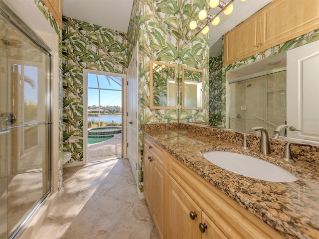 bathroom with vanity, a shower with door, and a water view