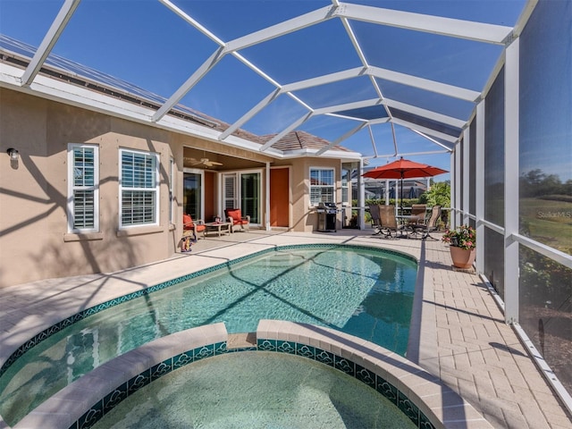 view of pool featuring an in ground hot tub, ceiling fan, a lanai, and a patio