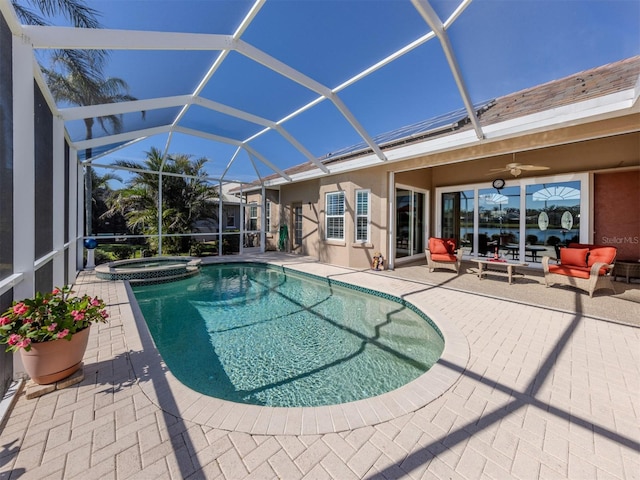 view of swimming pool with a lanai, an in ground hot tub, ceiling fan, an outdoor living space, and a patio