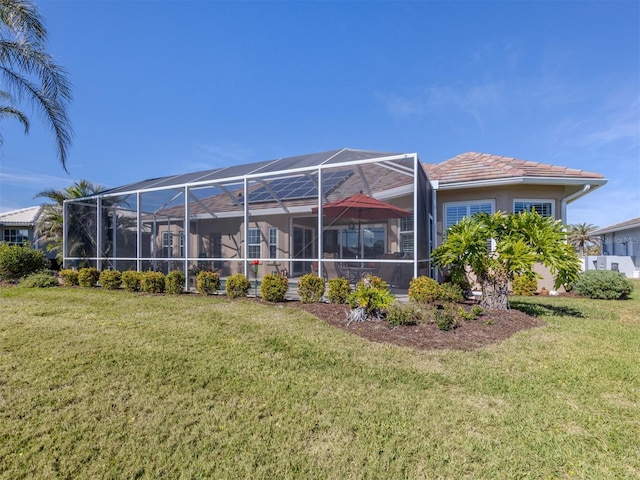 rear view of property with a lanai and a yard