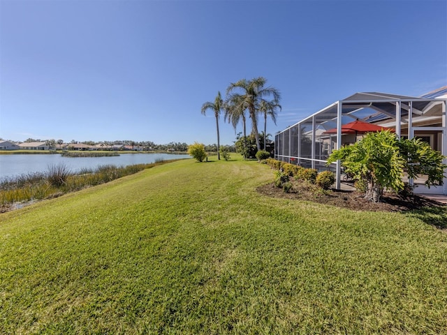 view of yard with a water view and glass enclosure