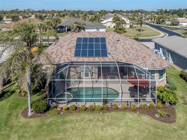 exterior space featuring a lanai, a lawn, a patio, and solar panels