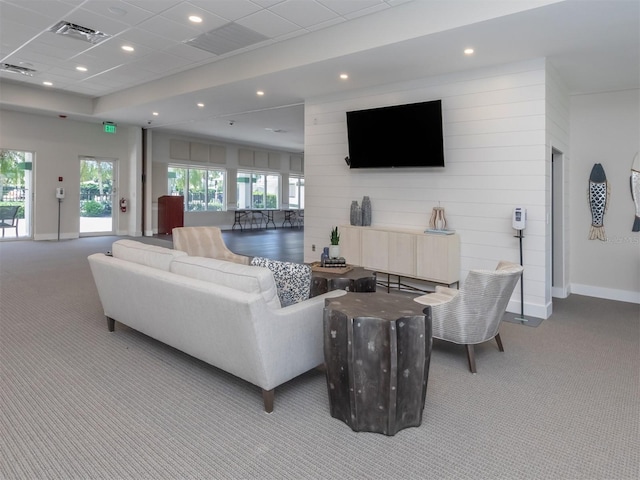 living room featuring light carpet and a drop ceiling