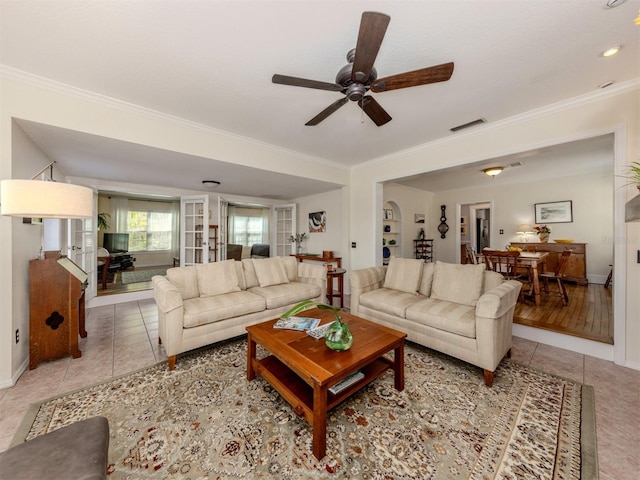 tiled living room featuring crown molding and ceiling fan