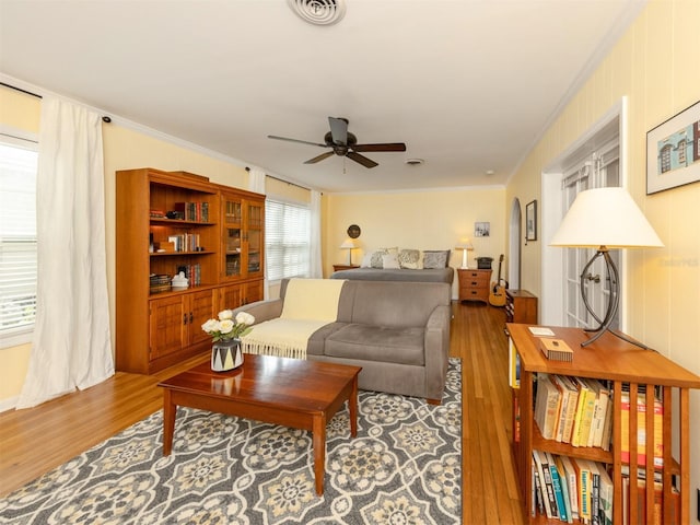 living room featuring hardwood / wood-style flooring, ornamental molding, and ceiling fan