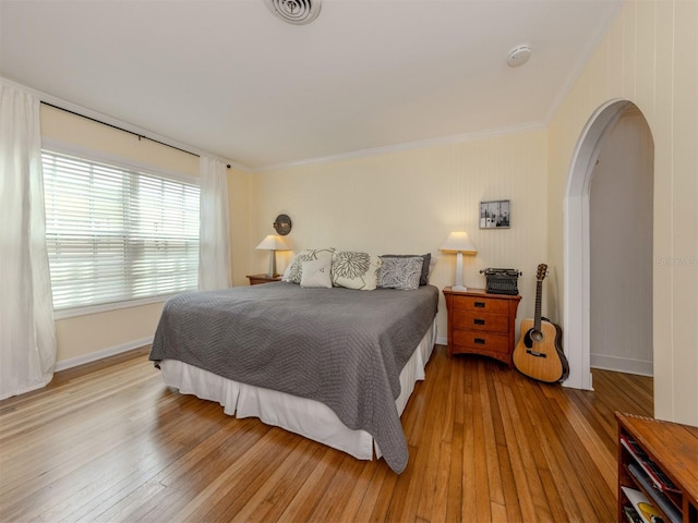 bedroom featuring ornamental molding and light hardwood / wood-style flooring