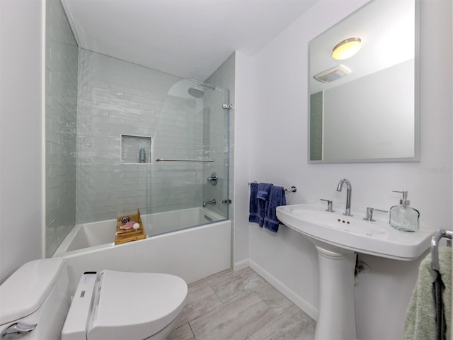 bathroom featuring tile patterned flooring, tiled shower / bath, and toilet