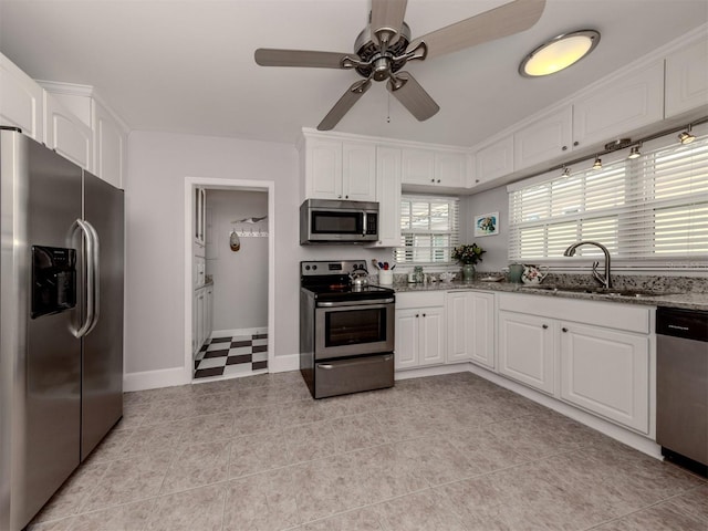 kitchen featuring light tile patterned flooring, sink, light stone counters, stainless steel appliances, and white cabinets