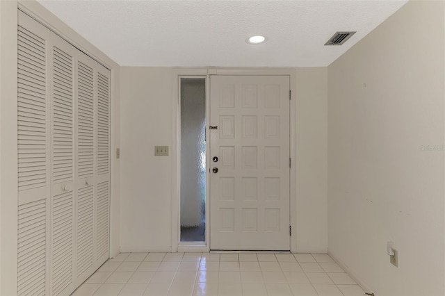 tiled entrance foyer with a textured ceiling