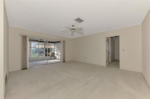 carpeted spare room with a textured ceiling and ceiling fan