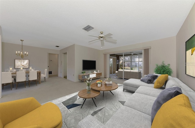 living room with ceiling fan with notable chandelier, light carpet, and a textured ceiling