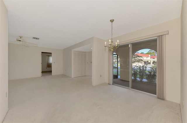 spare room with ceiling fan with notable chandelier, light colored carpet, and a textured ceiling