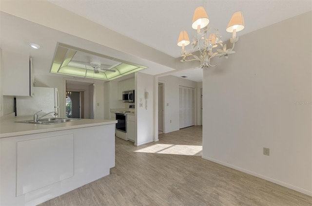 kitchen featuring white cabinetry, hanging light fixtures, white appliances, and a raised ceiling