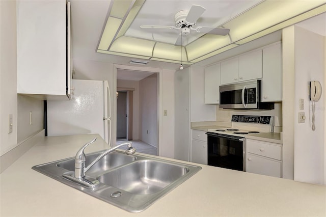 kitchen with sink, ceiling fan, range with electric cooktop, white refrigerator, and white cabinets