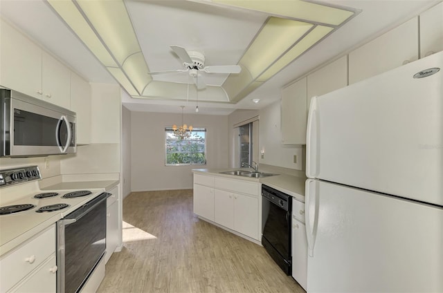 kitchen with white appliances, a raised ceiling, sink, and white cabinets