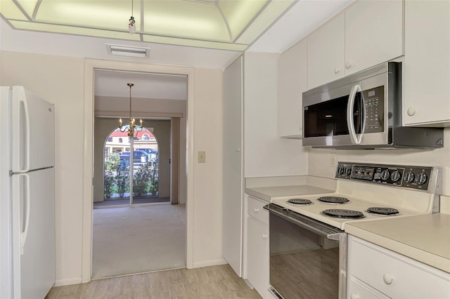 kitchen with white cabinetry, white appliances, pendant lighting, and light hardwood / wood-style flooring