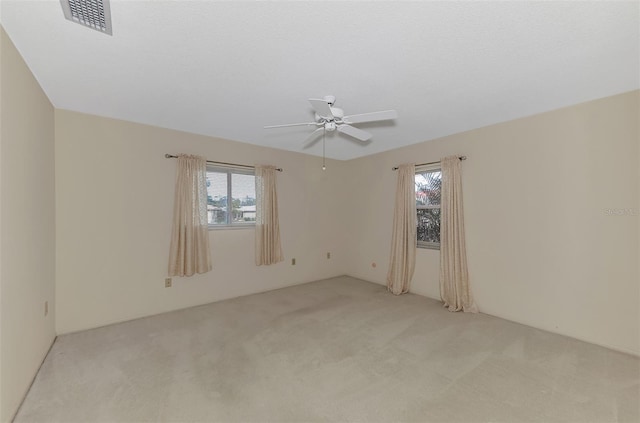 unfurnished room featuring ceiling fan and light carpet