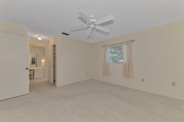 carpeted empty room featuring a textured ceiling and ceiling fan