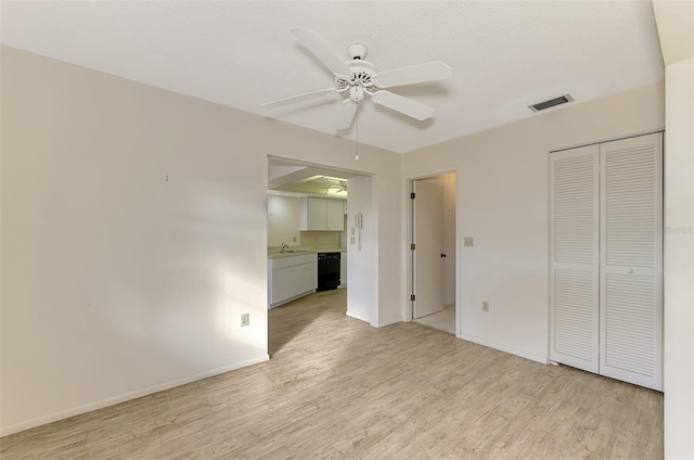 unfurnished bedroom with connected bathroom, sink, a closet, ceiling fan, and light hardwood / wood-style floors