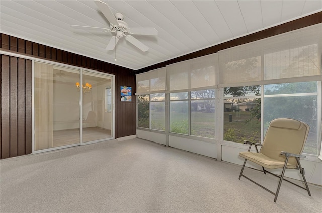 unfurnished sunroom featuring ceiling fan with notable chandelier