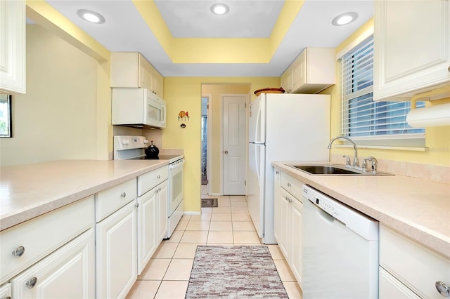 kitchen with light tile patterned flooring, white appliances, a raised ceiling, and sink