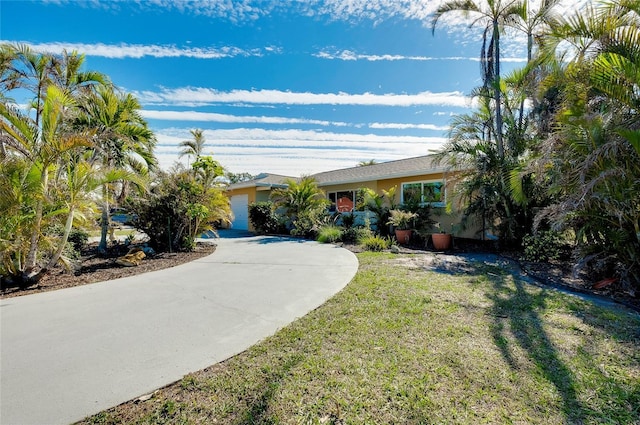 ranch-style house with a garage and a front yard