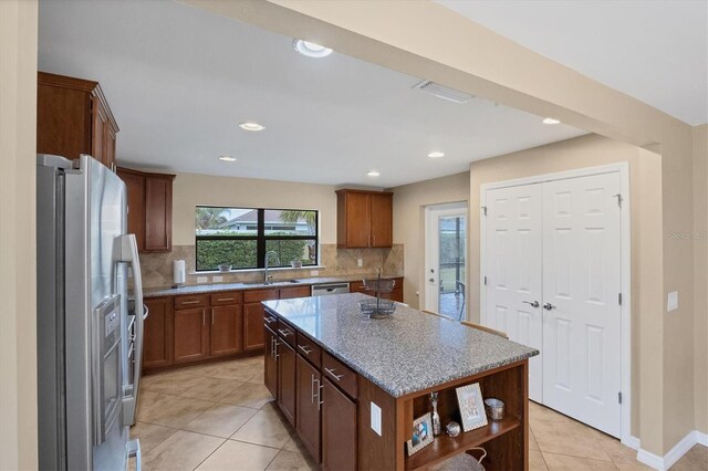 kitchen featuring stainless steel appliances, tasteful backsplash, a center island, and sink