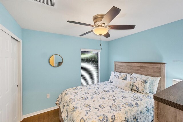 bedroom featuring dark hardwood / wood-style flooring, a closet, and ceiling fan