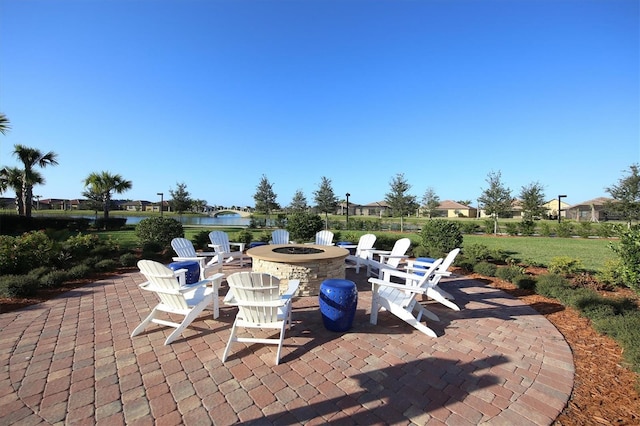 view of patio featuring a water view and a fire pit