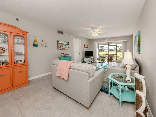 living room with a textured ceiling and ceiling fan