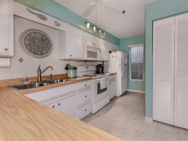 kitchen featuring wood counters, white cabinetry, sink, light tile patterned floors, and white appliances