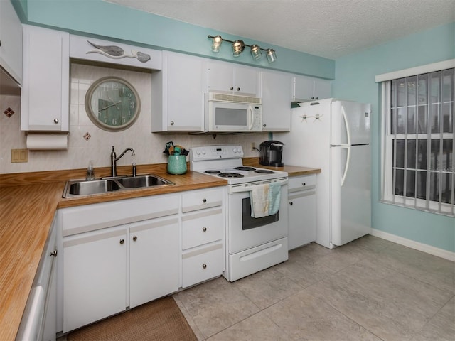 kitchen featuring white cabinetry, sink, backsplash, white appliances, and a textured ceiling