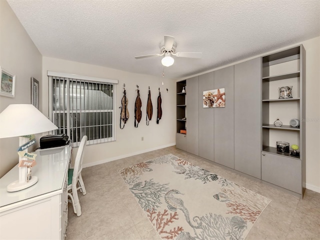 home office with ceiling fan and a textured ceiling