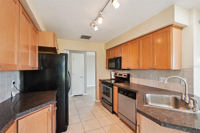 kitchen with light tile patterned flooring, sink, decorative backsplash, and black appliances