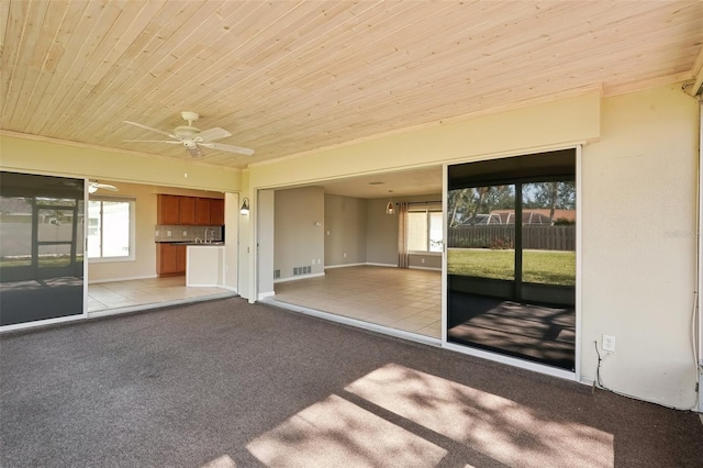 unfurnished living room featuring ceiling fan, wooden ceiling, and light tile patterned floors