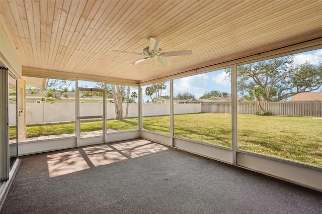 unfurnished sunroom featuring wood ceiling and ceiling fan