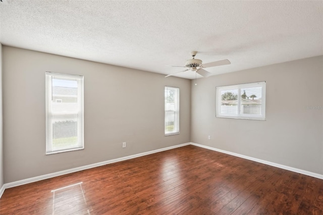 empty room with dark wood-type flooring, a textured ceiling, and ceiling fan