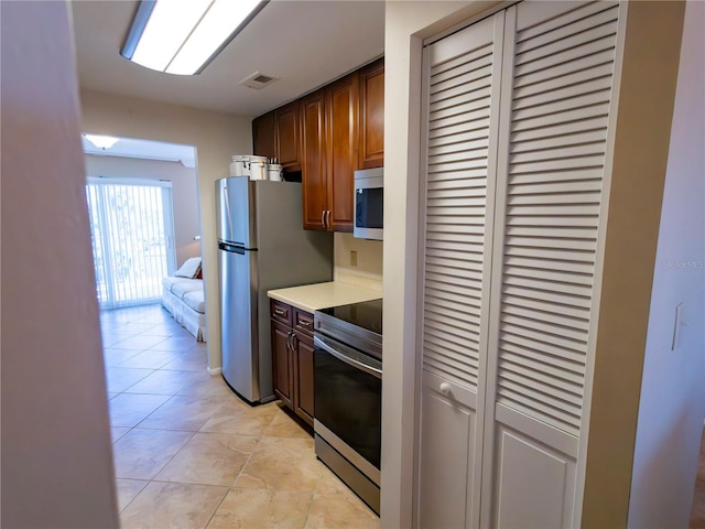 kitchen with light tile patterned floors and appliances with stainless steel finishes